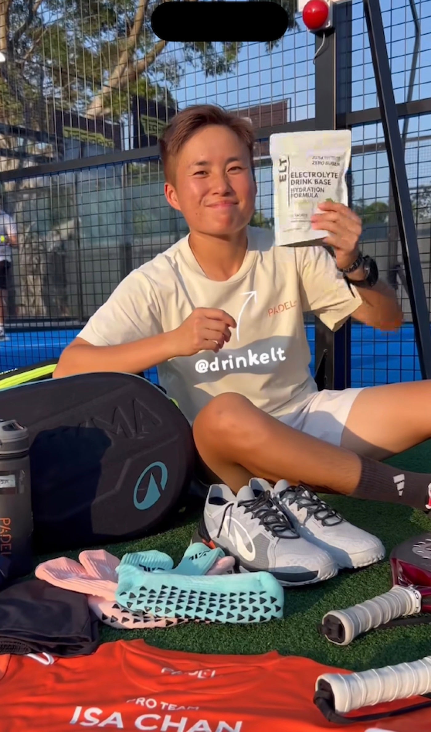 Isa Chan with ELT. Direct mid-morning sun, pouch in hand.